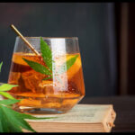 A cannabis leaf garnishes a cocktail glass, representing THCa-infused mixology.